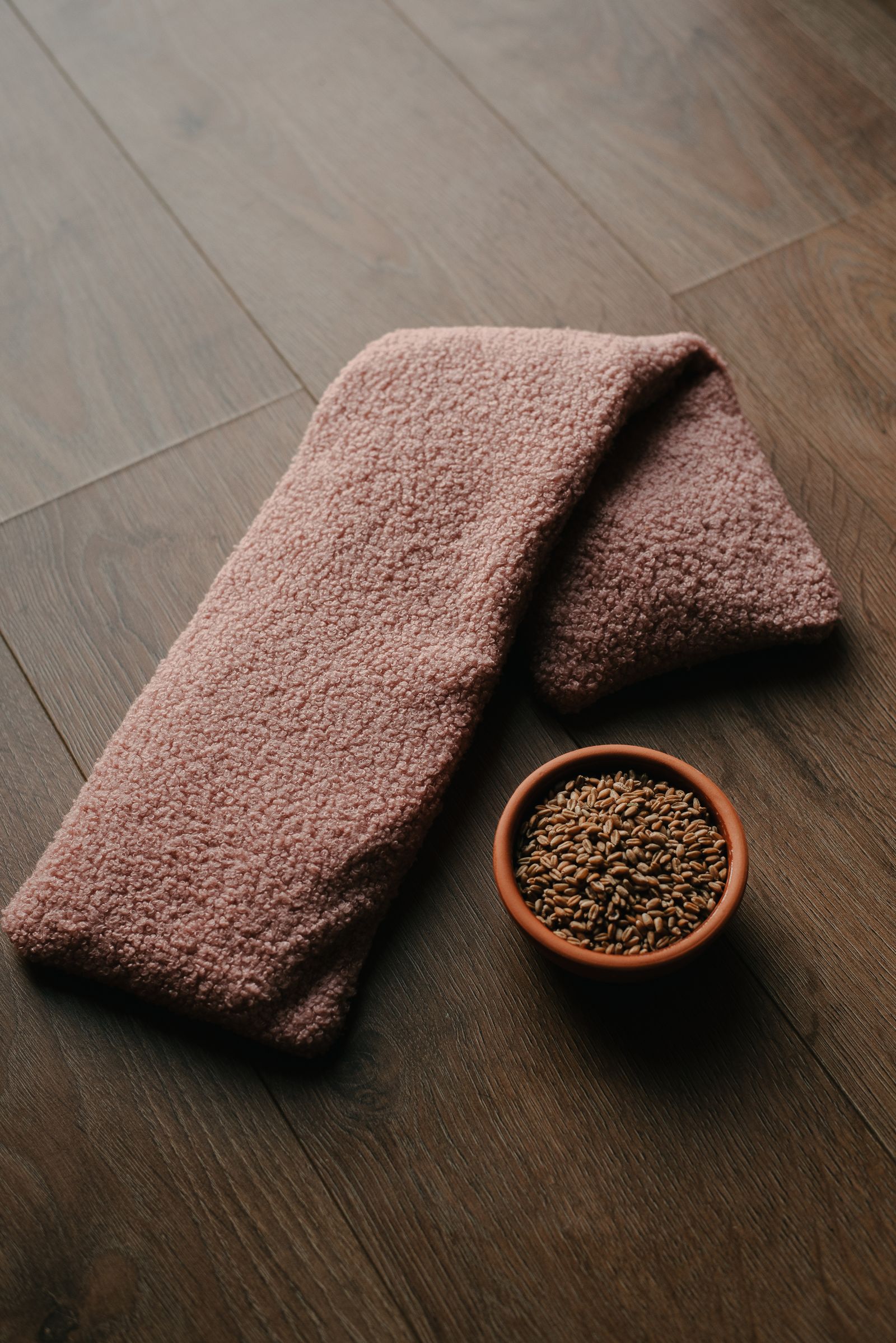 Schaaltje biologische tarwe naast een roze pittenzak